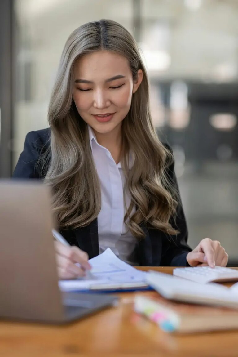 business Asian woman or accountant Bookkeeper working on calculator to calculate business data,