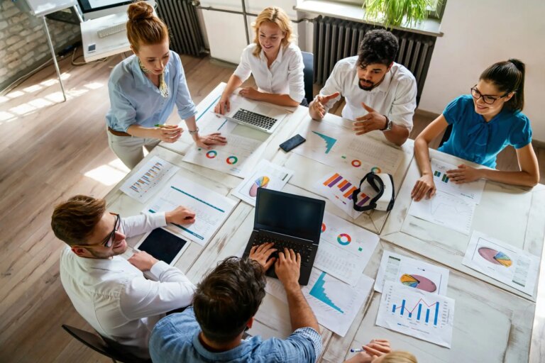 Diverse businesspeople discuss financial report in charts diagrams and graphs in meeting