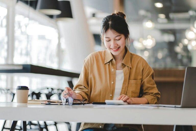 Portrait of an Asian woman working on a tablet computer in a modern office. Make an account analysis