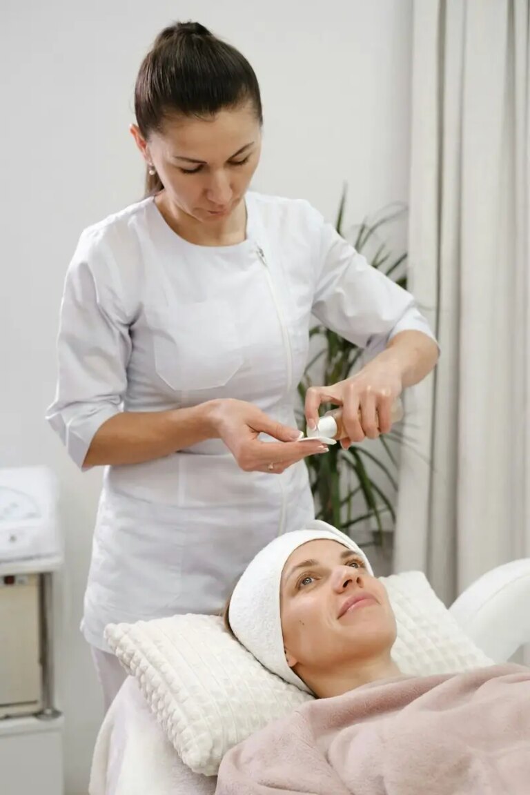 Woman applies tonic, cleaning skin procedure in aesthetic clinic